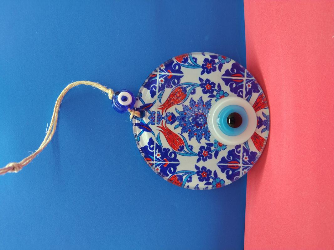 Decorative evil eye bead with tile and tulip patterns.