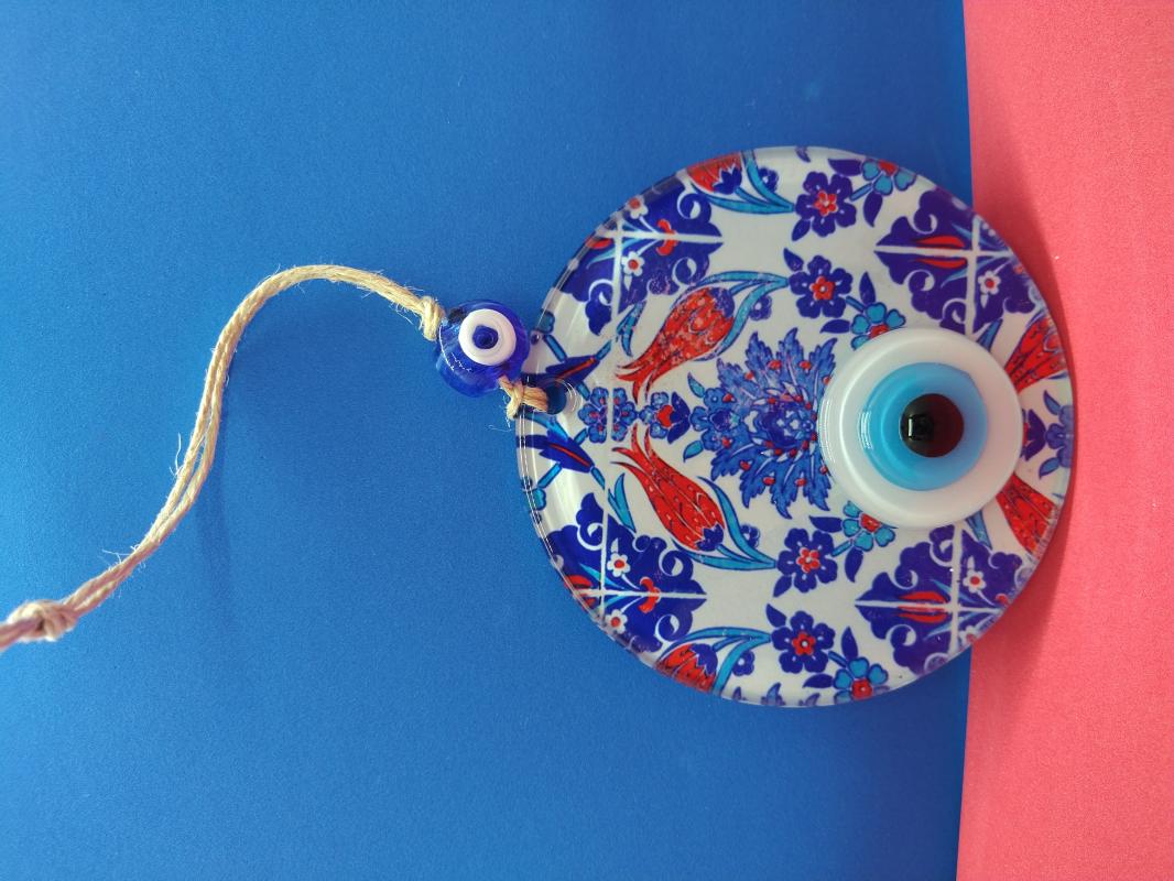 Decorative evil eye bead with tile and tulip patterns.